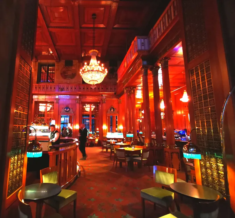 Stimmungsvolle Bar im Kurhaus Wiesbaden mit roter Beleuchtung, Holztäfelung, Kronleuchter und Sitzgelegenheiten