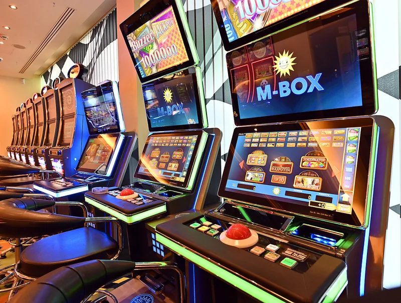 Detailansicht beleuchteter moderner Spielautomaten mit großen Bildschirmen im Ring Casino