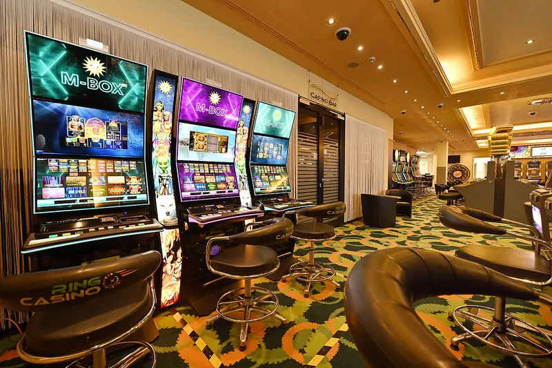 Reihe von M-BOX Spielautomaten im Innenbereich des Ring Casino mit Drehhockern
