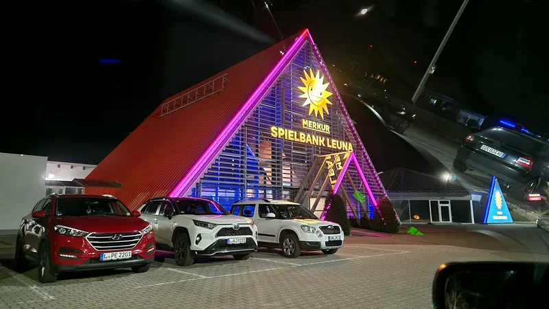 Beleuchtete Fassade der MERKUR SPIELBANK Leuna bei Nacht